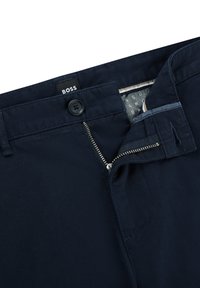 Navyblauwe chino's van katoen, voorzien van een knoopsluiting, metalen ritssluiting en een merklabel. Glad textuur met subtiele stikdetails.