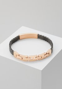 Armband met een roségouden metalen band met schakels en een gestructureerd grijs geweven gedeelte. Slank ontwerp met een moderne uitstraling.