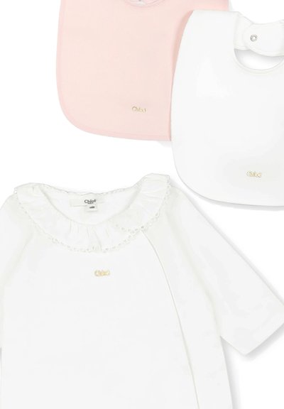 Trois bavoirs pour bébé en rose, blanc et blanc avec un col à volants ; chacun présente un logo doré. Tissu doux et lisse avec des formes arrondies.