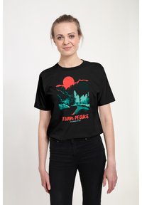 Černé tričko s potiskem horské krajiny a červeným sluncem. Design zahrnuje azurové stromy a cestu, s textem "TWIN PEAKS".