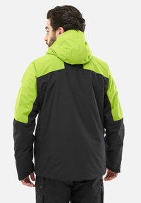 Veste à capuche avec un corps noir et des sections supérieures vert fluo, fabriquée en matériau imperméable avec une texture lisse et un design pratique.