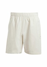 Light beige shorts with an elastic waistband. Textured fabric and a small logo detail near the hem. Casual, loose-fitting design.