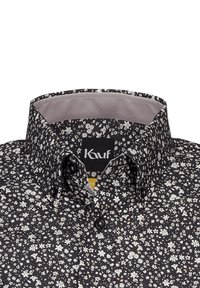 Schwarzes Blumen-Hemd mit Knopfleiste und einem strukturierten Muster aus kleinen weißen Blumen. Verfügt über einen strukturierten Kragen und ein Logotag im Nacken.