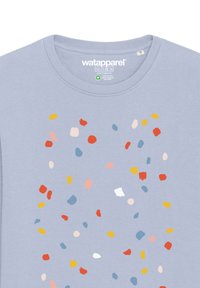 T-shirt en coton bleu clair présentant un motif de confettis multicolores avec des éclaboussures jaunes, rouges, rose pâle et bleues sur le devant.