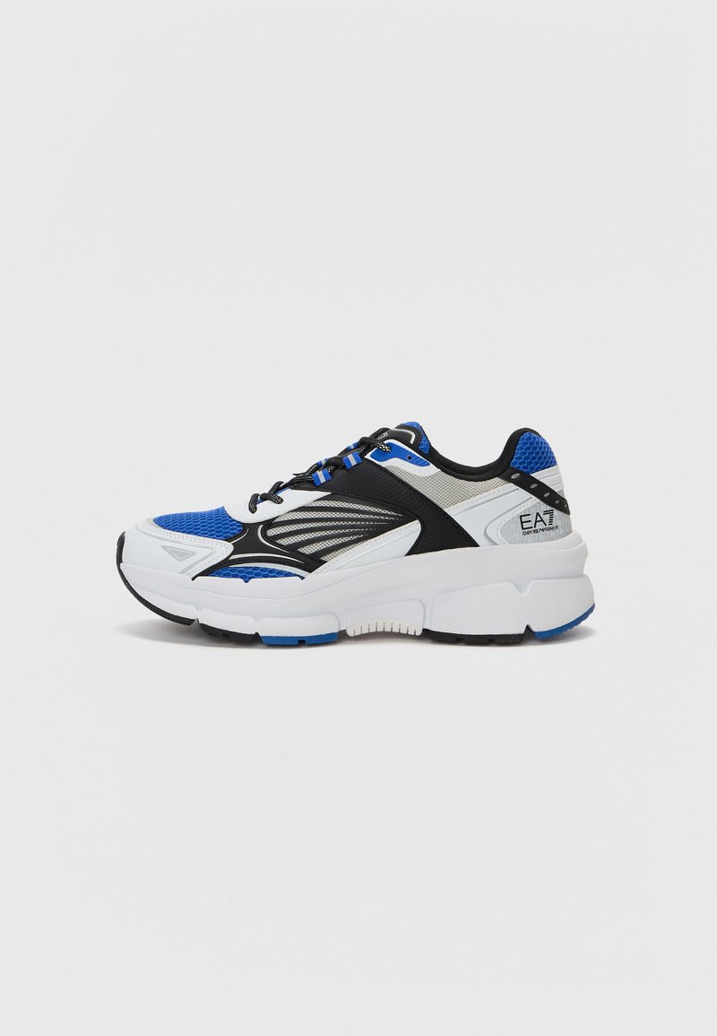 Sportowe sneakersy z białą, czarną i niebieską siateczką oraz syntetyczną cholewką. Posiadają grubą podeszwę środkową oraz teksturowane akcenty. Na języku znajduje się logo.