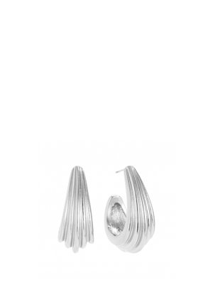 Curved silver hoop earrings with ribbed design, one showing front view and the other angled to display post and inner texture.