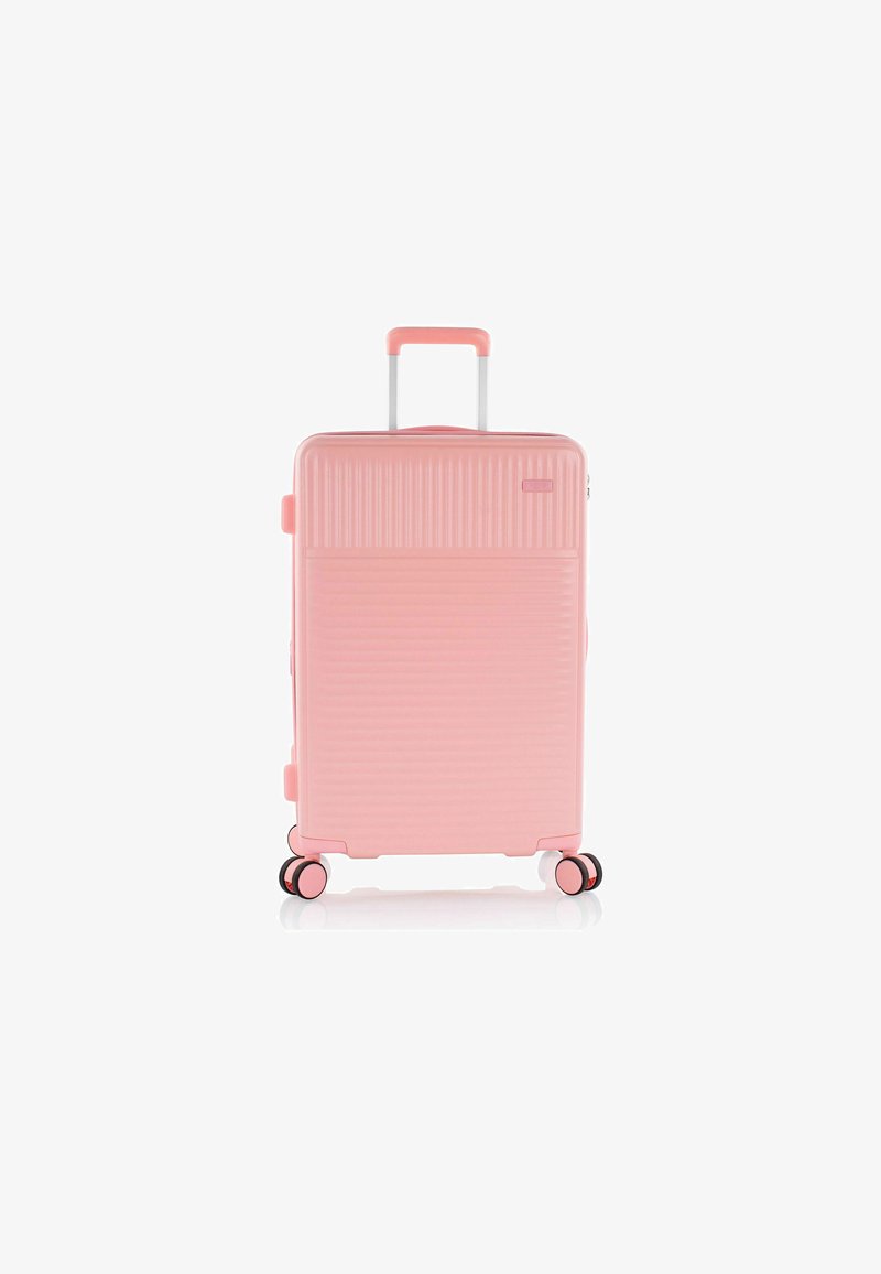 Valise rigide rose avec des rainures verticales, une poignée rétractable et quatre roues multidirectionnelles. Dispose de deux poignées latérales.
