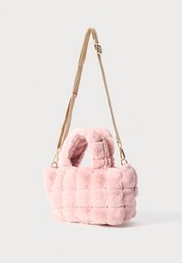 Roze faux fur handtas met een gequilt ontwerp, voorzien van korte handvatten en een afneembare goudkleurige schouderband. Gelaagd en zachte uitstraling.