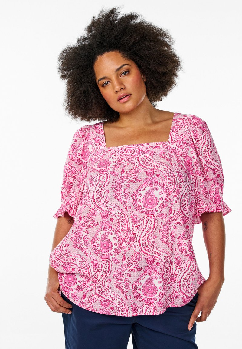 Bluzica s uzorkom u pink paisley boji, s kvadratnim izrezom i kratkim napuhanim rukavima. Izrađena od laganog materijala s lepršavim dizajnom.