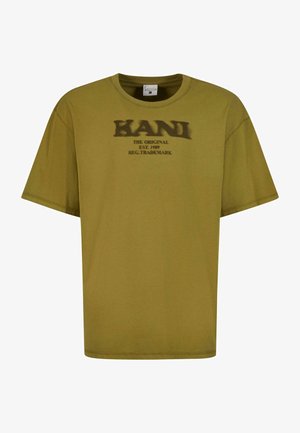 Olive roheline puuvillane T-särk lühikeste varrukatega, ümara kaelusega ja musta graafilise trükiga, millel on ees kiri "KANI THE ORIGINAL EST. 1989".