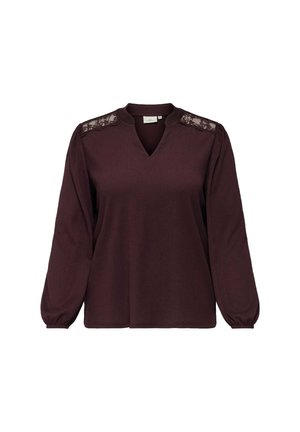 Top bordeaux à manches longues avec un décolleté en V, des accents en dentelle sur les épaules et des poignets ajustés. Tissu doux avec une coupe décontractée et une surface texturée.
