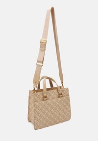 Beżowa torebka w wzory, wykonana z teksturowanego materiału, z podwójnymi uchwytami u góry, regulowanym paskiem i złotymi akcentami.