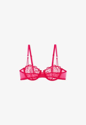 Pink lace bralette with sheer mesh cups, scalloped edges, and adjustable straps. It features a back hook closure and underwire support.