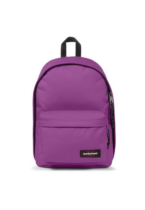 Mochila de tela morada con forma redondeada, un bolsillo con cremallera en la parte frontal y un asa superior. Presenta un zipper negro y un parche con el logo. Textura suave.