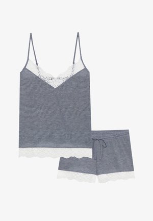 Šedý tílko s tenkými ramínky, se součástí bílé krajkové lišty kolem výstřihu a spodního lemu, spárované s odpovídajícími šedými šortkami s krajkovými detaily.