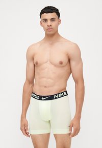 Svetlozelené boxerky Nike s čiernym pásom, na ktorom je logo Nike. Vyrobené z hladkého, elastického materiálu.