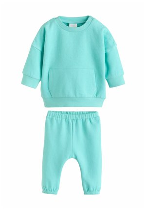 Lyseblåt bomulds sæt i to dele med en langærmet sweatshirt med frontlomme og matchende bukser med elastik i taljen.