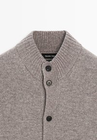 Szary sweter kardigan z prążkowanym kołnierzem, czterema czarnymi guzikami i miękką fakturą. Na metce przy dekolcie widnieje napis "Massimo Dutti".