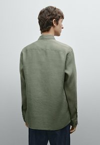 Langemouwig shirt in olijfgroen, gemaakt van textiel met textuur, met een klassieke kraag, knoopmanchetten en een gebogen zoom.