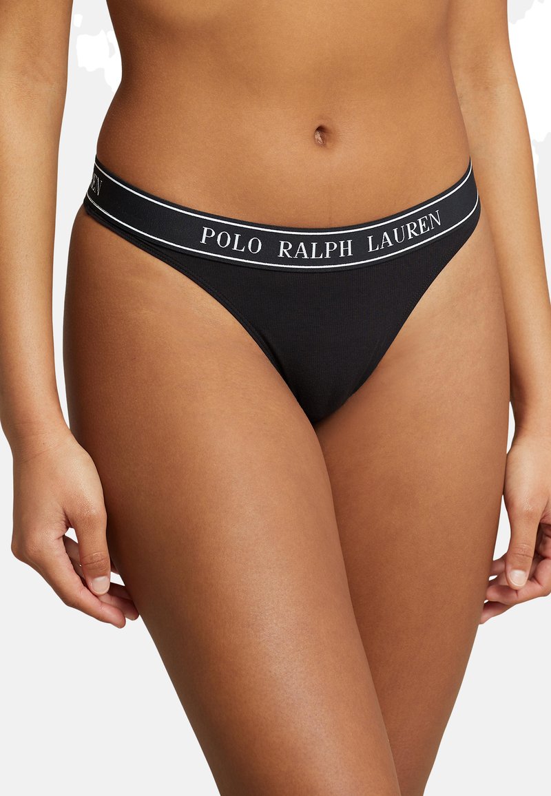 Melnas tanga apakšbikses, kas izgatavotas no mīkstas auduma ar elastīgu jostu, uz kuras baltiem burtiem izrakstīts zīmola nosaukums "POLO RALPH LAUREN".