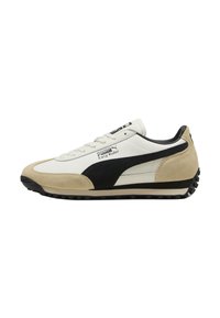 Witte leren sneakers met zwarte suède accenten en een beige tussenzool. Bevat een gestructureerde rubberen zool en logo-detailing aan de zijkant.