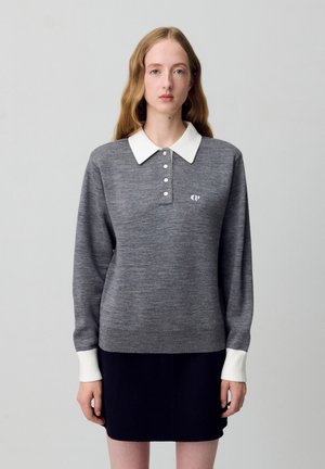Polo en tricot gris à manches longues avec un col blanc, patte de boutonnage et logo sur la poitrine. Fabriqué en tissu tricoté avec une texture lisse.