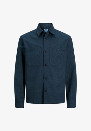 Tmavě modrá košile na knoflíky s texturovanou látkou, dvěma kapsami na prsou a klasickým límečkem. Má černé knoflíky a dlouhé rukávy.