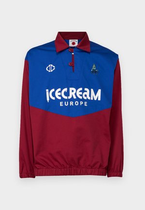 Červený a modrý pulóver s golierom, ktorý má veľké biele logo "icecream EUROPE", vyšívané akcenty a elastické manžety na páse a rukávoch.