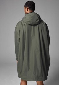 Olivgrüner, wasserdichter Parka mit Kapuze, lockerer Passform und Raglanärmeln; glatte Textur und belüftetes Design; bis zur Mitte der Oberschenkel reichend.