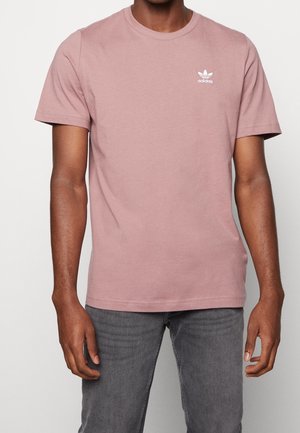 Lichtroze katoenen t-shirt met een ronde hals, korte mouwen en een wit Adidas-logo op de linkerborst. Soepele textuur, normale pasvorm.