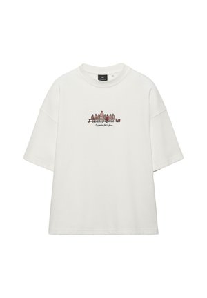 Maglietta bianca a maniche corte con una piccola grafica centrale di giocatori di basket seduti su una panchina e testo "La passione fa la forza."