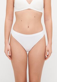 White ribbed cotton briefs with a wide elastic waistband, featuring minimal design and a close-fitting silhouette.