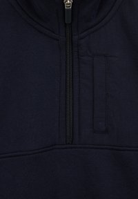 Navy modra zip-up sudbena jopica z visokim ovratnikom, navpičnim zadrgo in ravnimi šivi. Gladka tkanina s čistim, minimalističnim dizajnom.