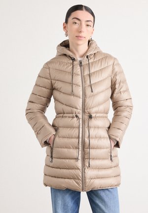 Veste matelassée beige à capuche avec un design ajusté, un motif matelassé vertical, une taille à cordon de serrage et une fermeture éclair à l'avant. Dispose de poches latérales.