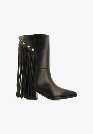 Botas de cuero negro hasta el tobillo con punta afilada, que presentan tachuelas doradas y flecos largos negros en el exterior para un detalle adicional. Diseño de tacón cuadrado.