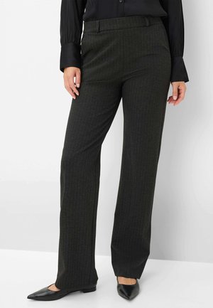 Dunkelgrüne Nadelstreifen-Hosen aus weichem Stoff, mit einer taillierten Passform und flachem Bund, kombiniert mit schwarzen spitz zulaufenden Ballerinas.