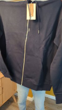 Navy zip-up hoodie made from soft fabric; features a front zipper, two side pockets, and adjustable drawstring hood. Tag attached.
