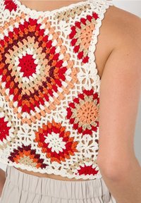 Gehaakte crop top met geometrische patronen in rood, oranje, beige en wit. Ontwerp met open rug en ingewikkelde kantdetails. Van katoen.