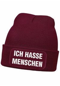 Maroon knit beanie with a folded cuff featuring a rectangular patch that reads "ICH HASSE MENSCHEN" in bold white letters.