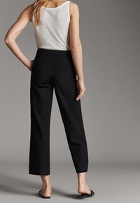 Zwarte cropped broeken met een hoge taille, een gladde textuur en een rechte pijpdesign, gecombineerd met een witte tanktop en zwarte slides.