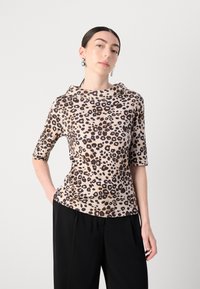 Leopard print top in light beige with short sleeves and a cowl neck design, made from soft fabric, paired with black wide-leg trousers.
