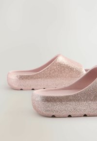 Roze glitterklompen met een afgerond ontwerp, platte zolen en een glad interieur. De buitenkant schittert met een grove textuur, wat zorgt voor een glanzende afwerking.