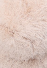 Tessuto in pelliccia sintetica di colore rosa pallido e soffice, con lunghe fibre morbide che creano una superficie pelosa e testurizzata, ideale per cuscini o decorazioni.