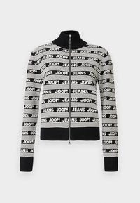Black and white zippered sweater with high collar, featuring repeating text patterns "JEANS" and "JOOP!" across the fabric.