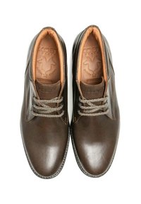 Une paire de chaussures en cuir marron foncé à lacets avec une doublure intérieure tan, vue de dessus sur un fond blanc.