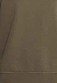 Tessuto della felpa verde oliva con una texture liscia, caratterizzato da una cucitura orizzontale all'orlo e una leggera elasticità. Nessun motivo o decorazione.