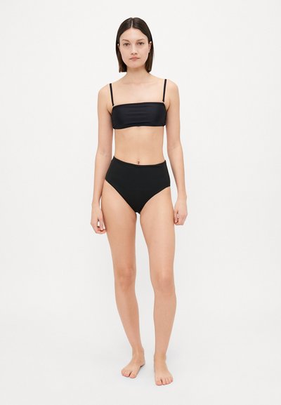 Musta bikinit, joissa on bandeau-mallinen yläosa kapeilla remmeillä ja korkeat alushousut. Sileä pinta, minimalistinen muotoilu ja tiukka siluetti.
