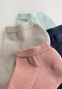 Fire par ankelsokker i beige, lyseblå, marineblå og støvet lyserød. De har ribbede kanter og et glat, struktureret stof.