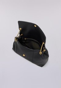Borsa a tracolla in pelle nera con catene dorate, chiusura a scatto superiore e tasca interna con zip. Texture morbida e forma strutturata.