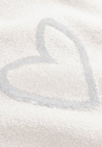 Witte stof met een zachte, gestructureerde oppervlakte waarop een lichtgrijze hartvormige patroon is aangebracht.